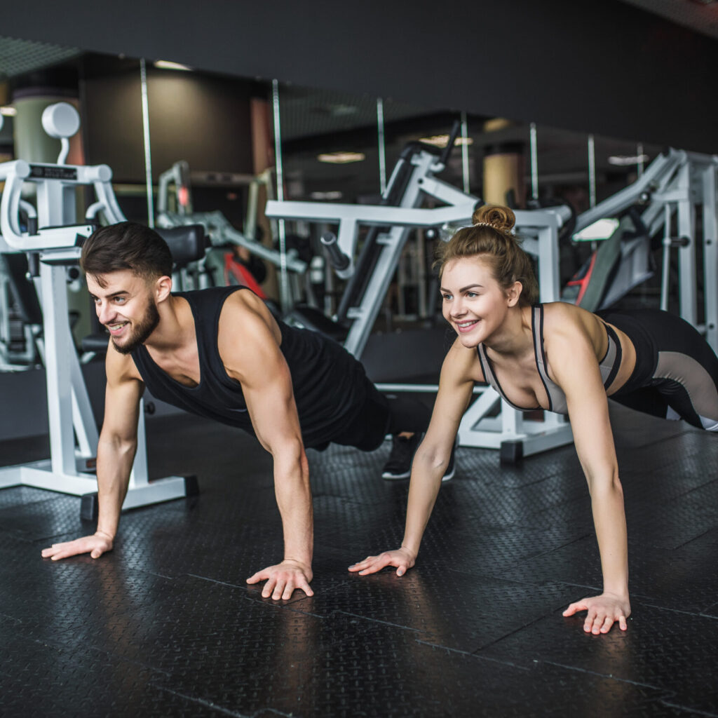 motivated-young-blond-woman-man-middle-workout-standing-plank-with-hands-clenched-together-scaled.jpg